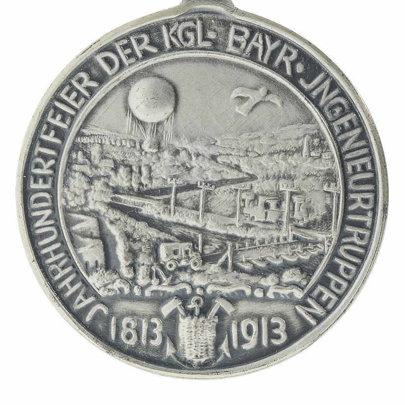Silberne Münze mit kleinteiligem Bild, Farbfoto.